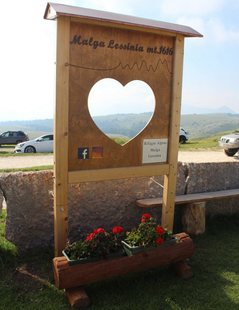 Bacheca in legno incisa e scavata con pali in larice e lamiera protettiva sul tettuccio